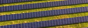 Aerial view over ground-mounted solar panels station