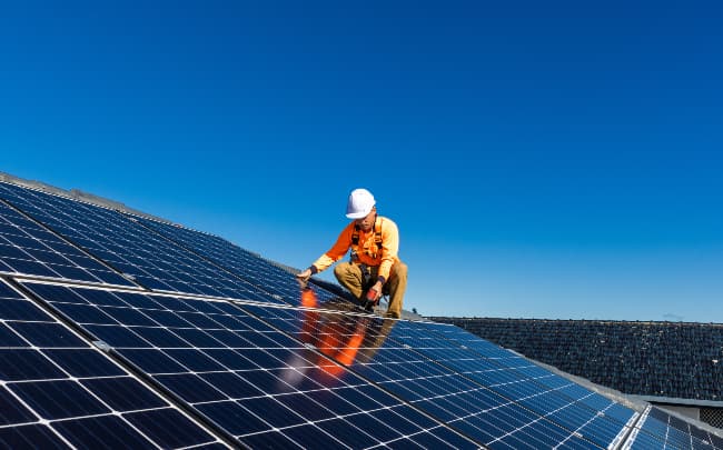 worker on solar panels